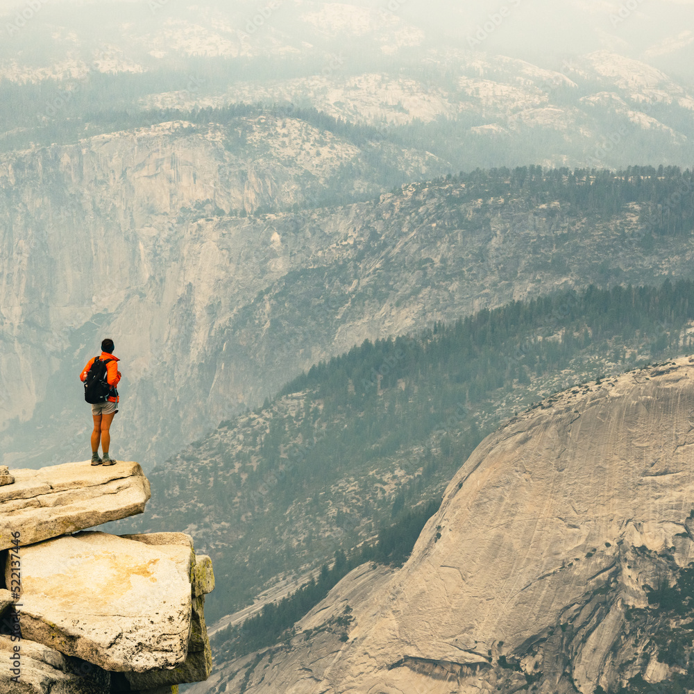Obraz premium Woman Stands On The Edge of Cliff On Half Dome