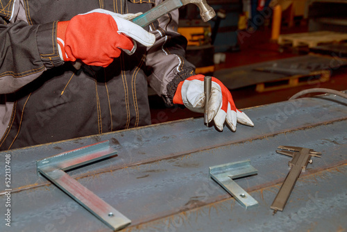 The worker makes a mark on a metal surface by means of Measuring square. Drilling holes in metal.