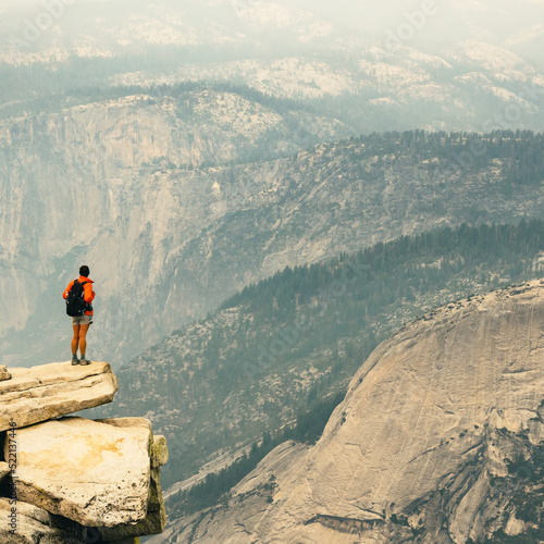 Woman Stands On The Edge of Cliff On Half Dome