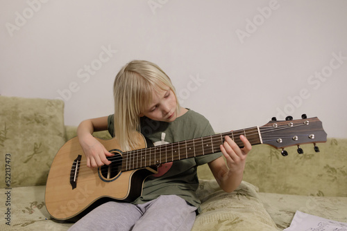  Little girl playing guitar at home photo