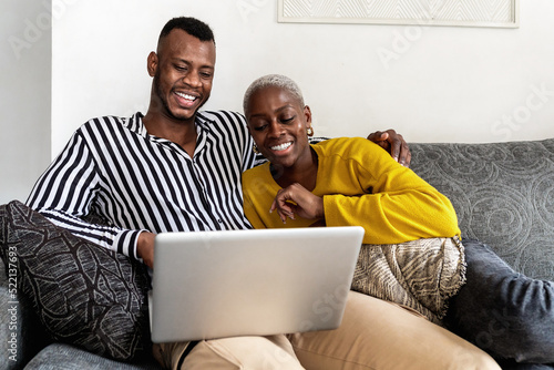 Merry black couple watching video on netbook photo