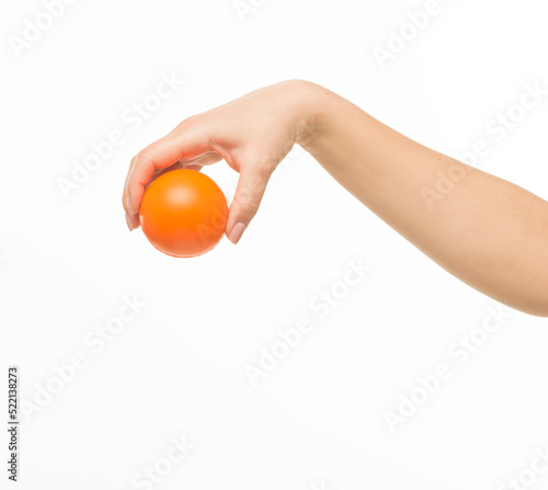 female hands holding an orange sponge ball on a white background isolated