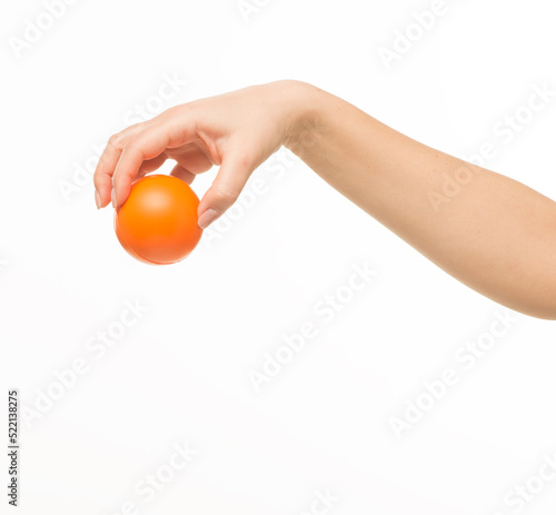 female hands holding an orange sponge ball on a white background isolated