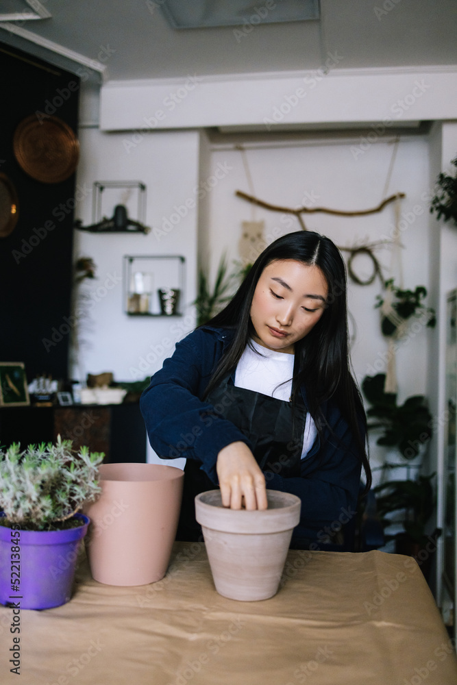 Gardener filling flowerpot with special mixture for plant Gardener filling flowerpot with special mixture for plant