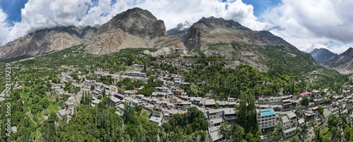 An aerial panorama of Baltit Fort, its surrounding mountains, and Hunza valley during the summer season.  photo