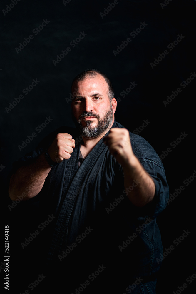 Bearded fighter practicing punches in darkness Bearded fighter practicing punches in darkness