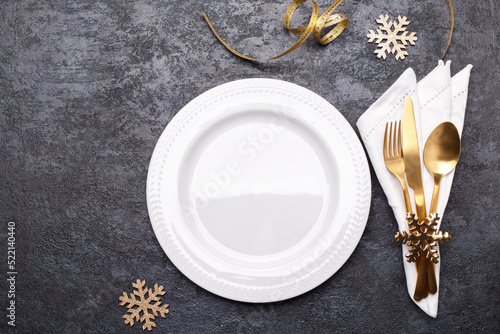 Christmas or new year table setting with golden cutlery