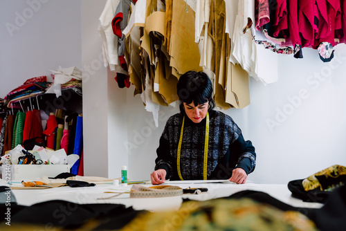 Obraz na płótnie Dressmaker woman measuring the garments to design them. w salonie