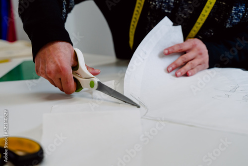 Obraz na płótnie Dressmaker with scissors cutting cloth. w salonie
