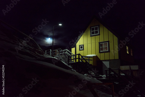 Greenland house winter polar night - village streetlight, dark clouds photo