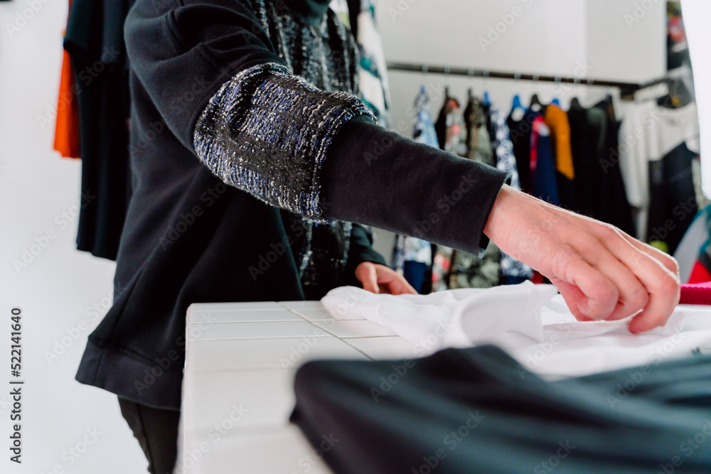 Woman folding clothes in her store