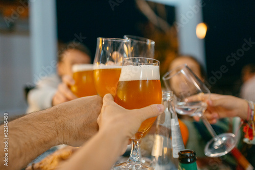 Detail of hands toasting with beers photo