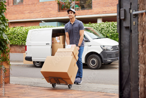 Male courier delivering parcels on hand truck