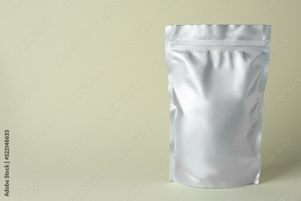 One blank foil package on beige background. Space for text One blank foil package on beige background. Space for text