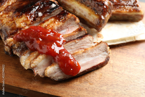Delicious grilled ribs with sauce on table, closeup
