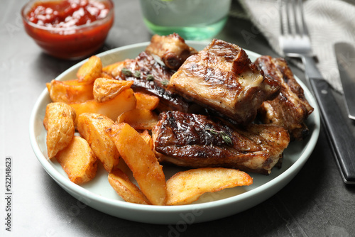 Delicious grilled ribs with potatoes on table © New Africa