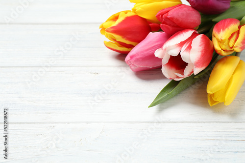 Fototapeta Naklejka Na Ścianę i Meble -  Beautiful spring tulips on white wooden table, closeup. Space for text