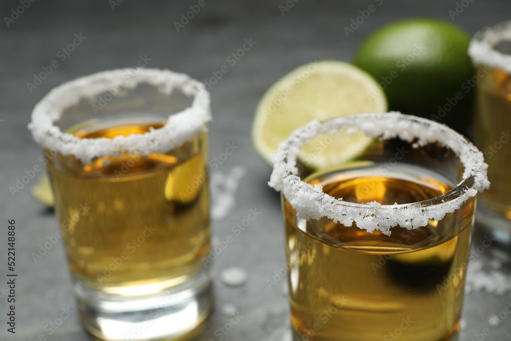 Mexican Tequila shots, with salt on grey table, closeup