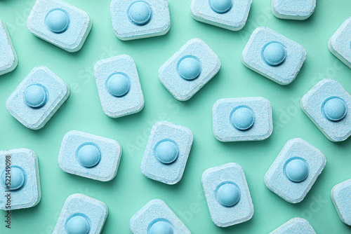 Water softener tablets on turquoise background, flat lay photo