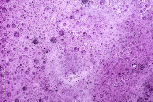 Purple foam texture. Foamed hand and body soap. Cosmetic product background.