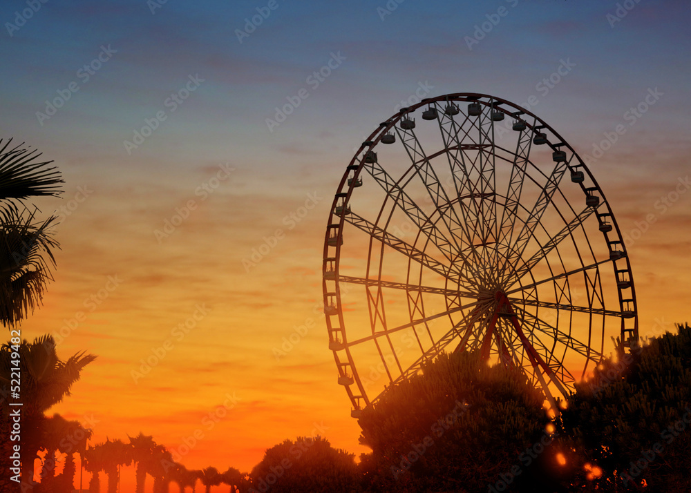 Beautiful large Ferris wheel outdoors at sunset