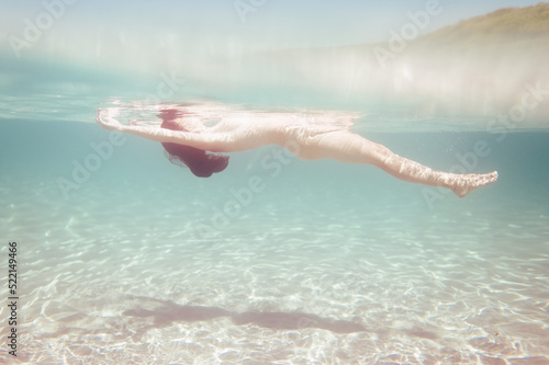 Anonymous woman floating on tropical sea photo