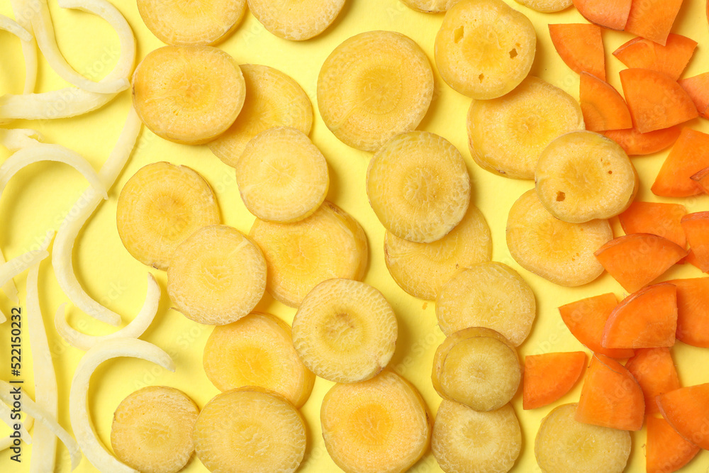 Pieces of raw color carrots on yellow background, flat lay Pieces of raw color carrots on yellow background, flat lay