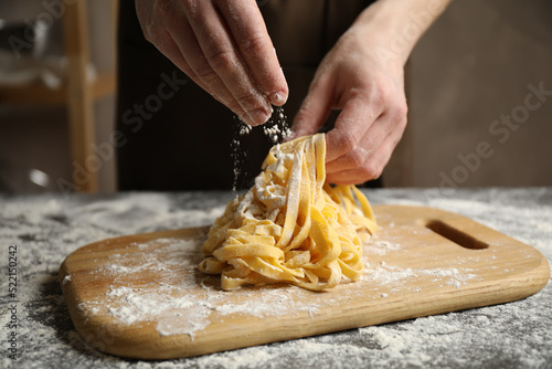 Woman preparing pasta at table, closeup view