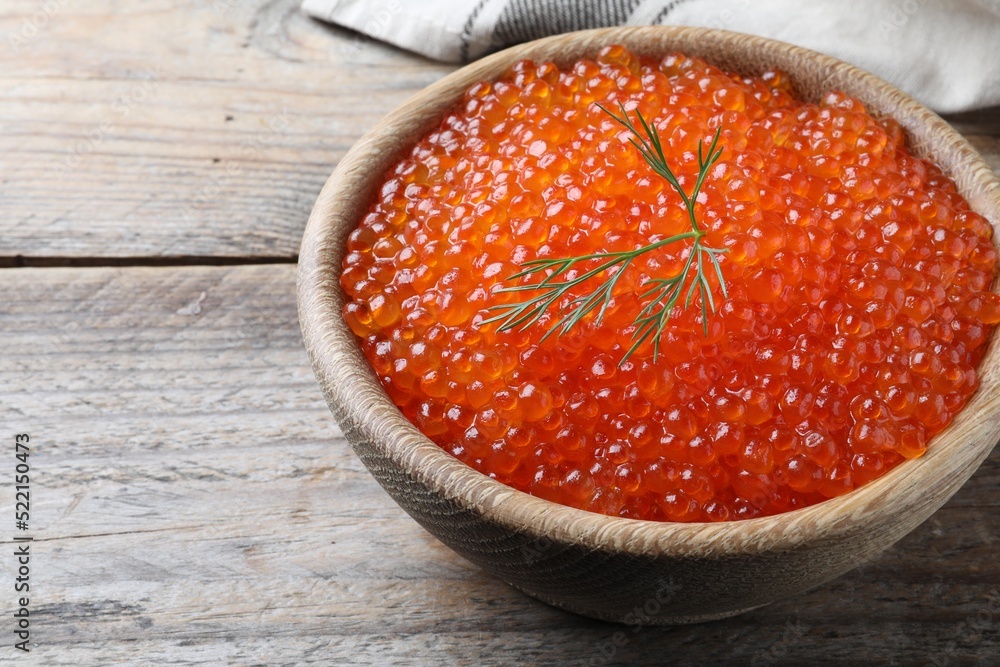 Bowl with delicious red caviar and dill on wooden table Bowl with delicious red caviar and dill on wooden table