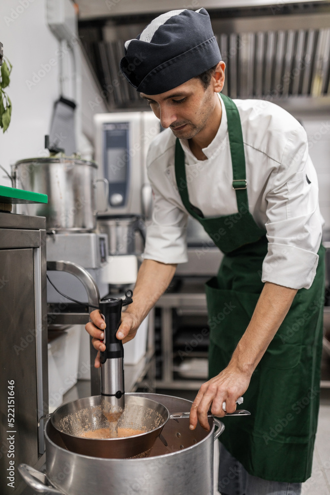chef beating vegetables in a restaurant kitchen chef beating vegetables in a restaurant kitchen