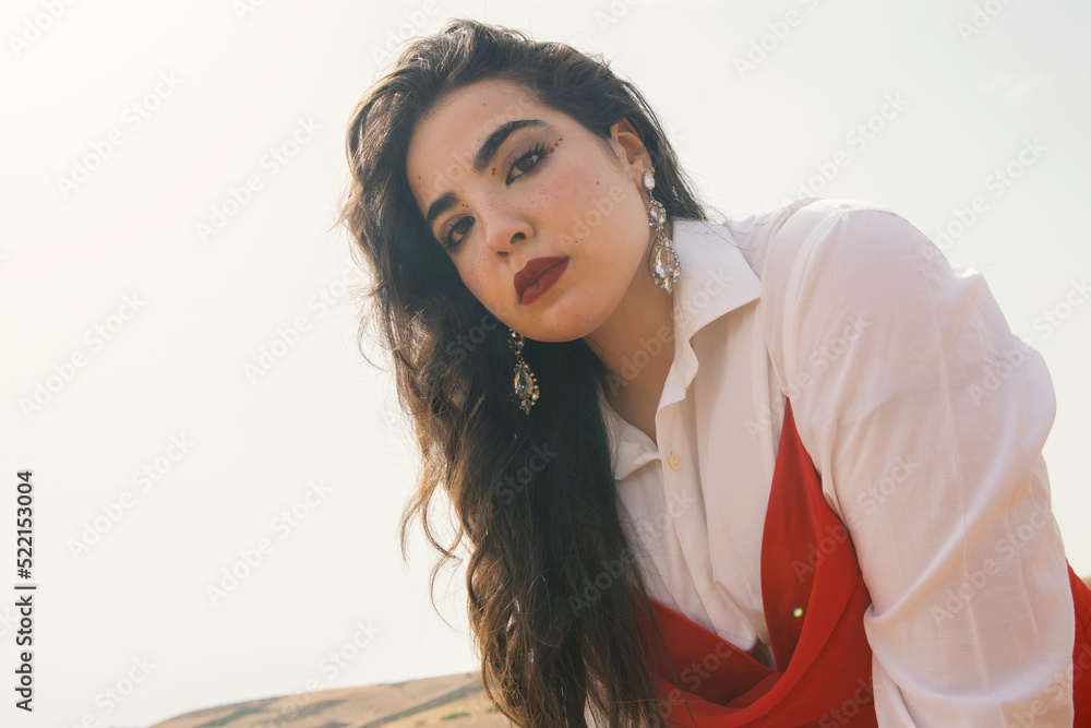 Beautiful young girl with long black hair wearing red dress in nature ...