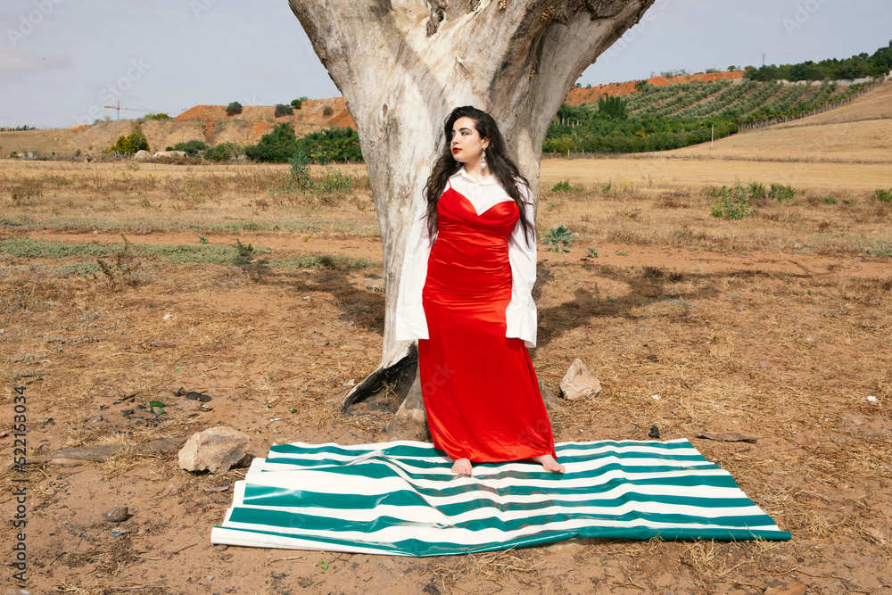 Beautiful young girl with long black hair wearing red dress in nature ...