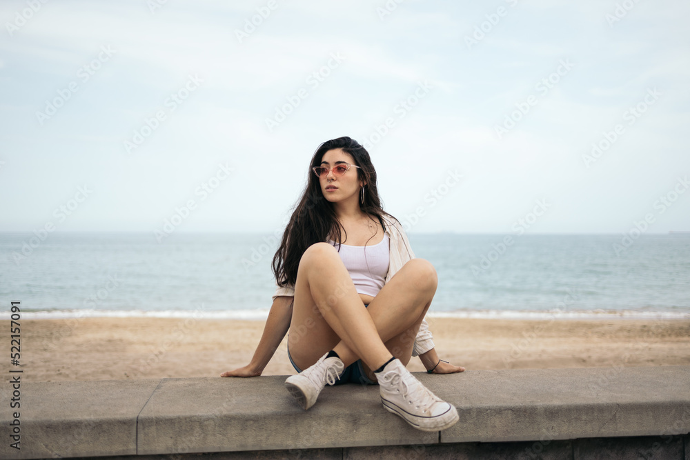 Stylish girl sitting near the beach