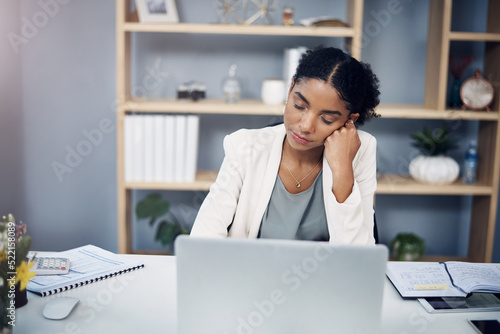 Tired, burnout and overworked woman working on a laptop in an office, sleepy and taking a nap. Young female suffering from fatigue and low energy, unfocused and struggling to manage an online task photo