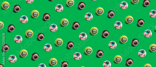 Different creepy candies for Halloween on green background