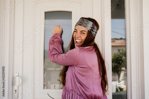Happy woman knocking on door photo