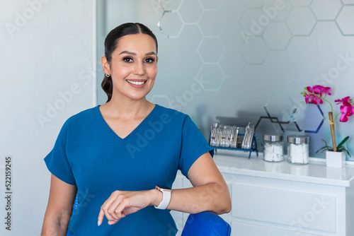 A smiling female dentist in blue uniform in a dental clinic  photo