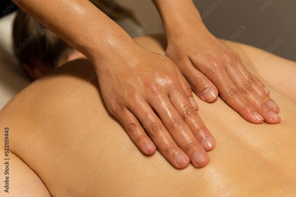 Woman's hands massaging a back at spa Woman's hands massaging a back at spa