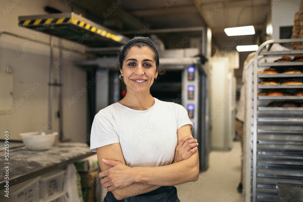 Artisan baker posing in the kitchen of her business Artisan baker posing in the kitchen of her business