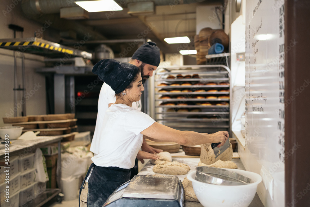 Co-workers at a bakery making artisan bread Co-workers at a bakery making artisan bread