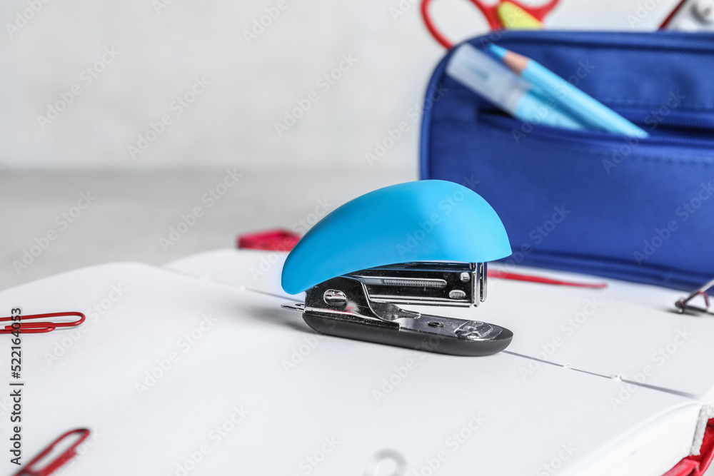 Stapler with stationery supplies on light background, closeup Stapler with stationery supplies on light background, closeup