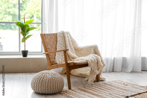 Cozy armchair with plaid an...