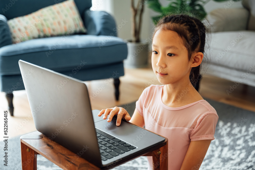 Little girl using laptop attending online tutorial Little girl using laptop attending online tutorial