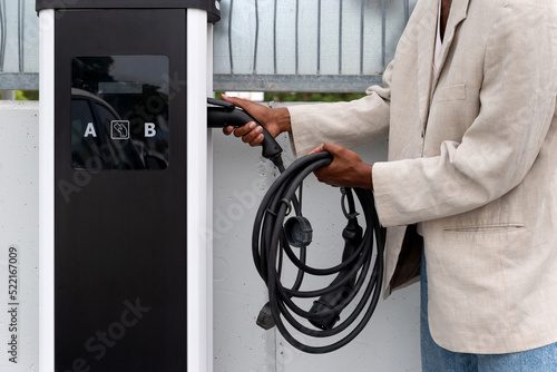 Black man charging his electric car