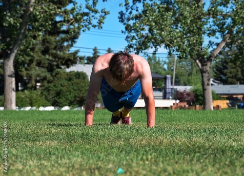 Mature man doing push ups in nature