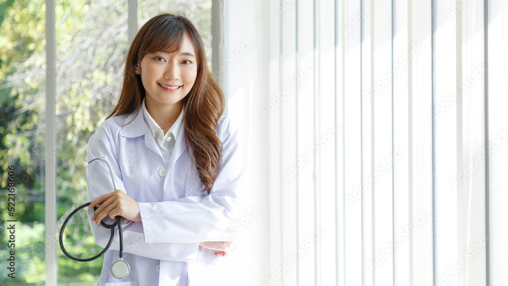 Beautiful and cheerful good mood young lady asian doctor dressed uniform smiling arm stethoscope on lobby hospital background. COPY SPACE. Beautiful and cheerful good mood young lady asian doctor dressed uniform smiling arm stethoscope on lobby hospital background. COPY SPACE.