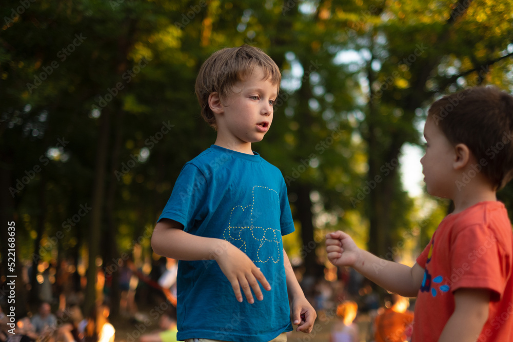 Kids are playing Rock, paper, scissors game in a park full of people
