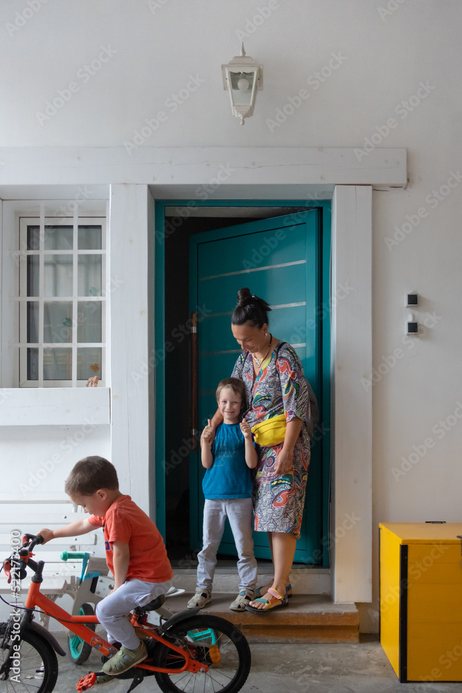 Family is standing In front of home door, posing for portrait Family is standing In front of home door, posing for portrait