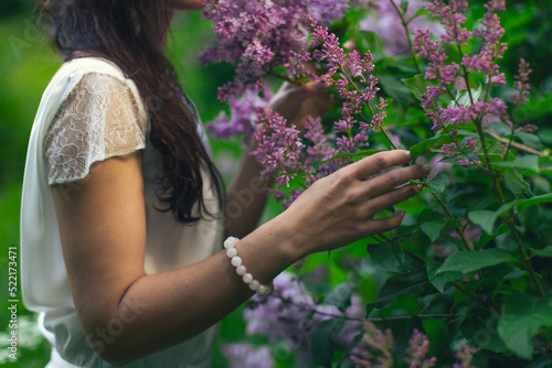 Hands of an attractive woman with a bouquet of lilacs. Spring and summer  seasonal photos. Front view.