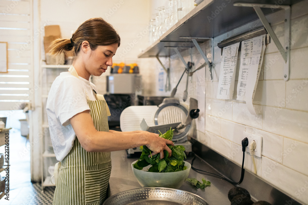 cafeteria worker making a salad in the store's kitchen cafeteria worker making a salad in the store's kitchen